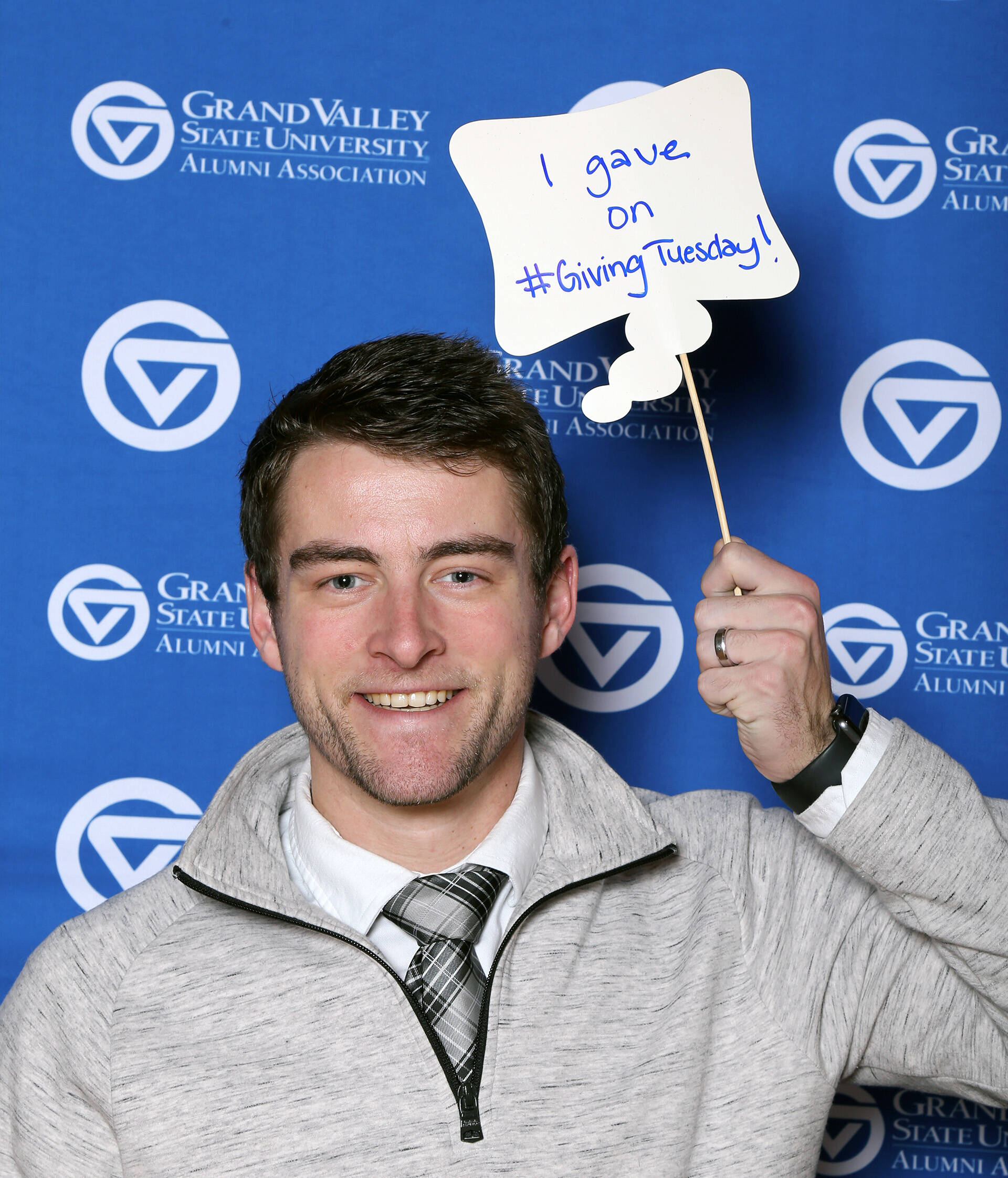Young man holding up sign that says I Gave on #GivingTuesday